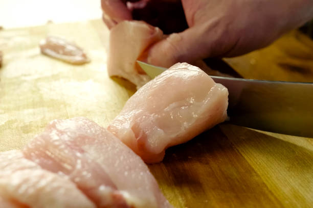 istock Cutting poultry meat. Broiler breast, chicken meat on cutting bo 1167331852