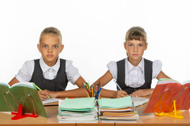 istock Two schoolgirls gaze intently and emotionlessly into the frame 1167332427