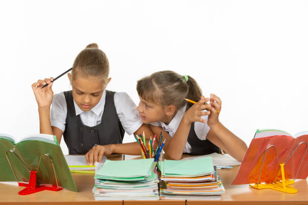 istock One girl pestering another at a lesson at school 1167332429