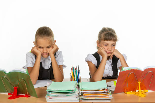 istock Sad schoolgirls look at textbooks in class 1167332433