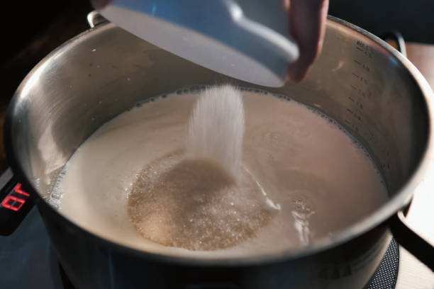 istock pouring sugar into milk into a pan on scales. 1167332838