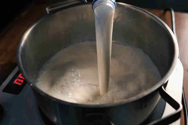 Pouring milk into the pan on scales. stock photo