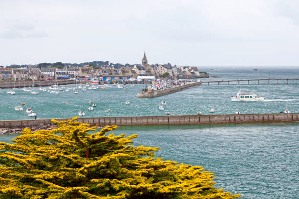 Roscoff, France - July 22 2017: Ferry from Batz Island entering the Port in Roscoff, with behind, the spire of the Église Notre-Dame de Croaz Batz.