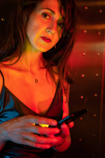 istock Beautiful woman using smartphone at night 1167342256