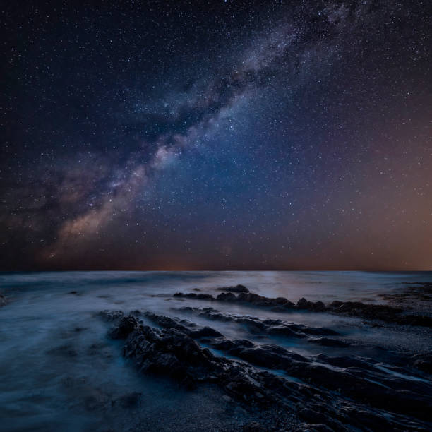 istock Stunning composite landscape image of Mily Way core over sea rocks and cliffs with long exposure tide on beach 1167343125