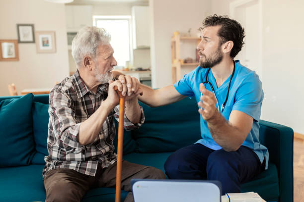 istock Male Caretaker Talking to Elder Man Patient 1167344256