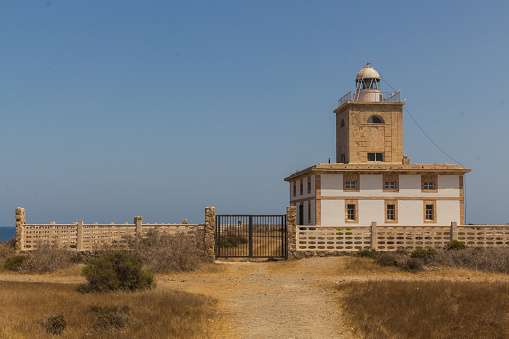 A Lighthouse at the end of a road on the popular tourist destination the Island of Tabarca near Alicante in  Spain