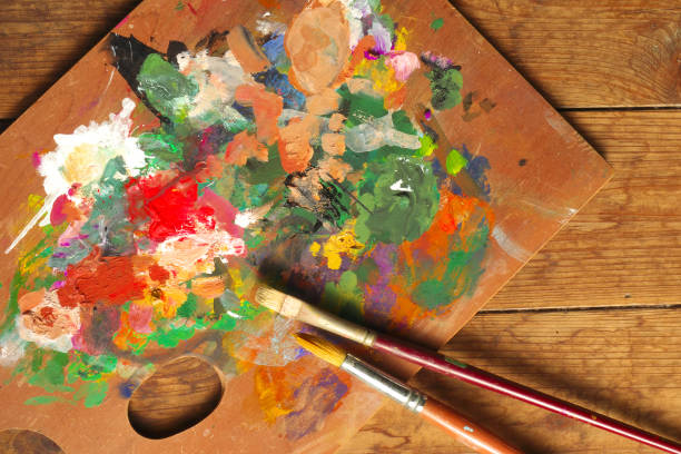 istock Palette and paintbrushes on wood background 1167354242