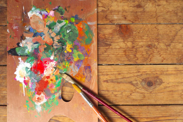 istock Palette and paintbrushes on wood background 1167354245
