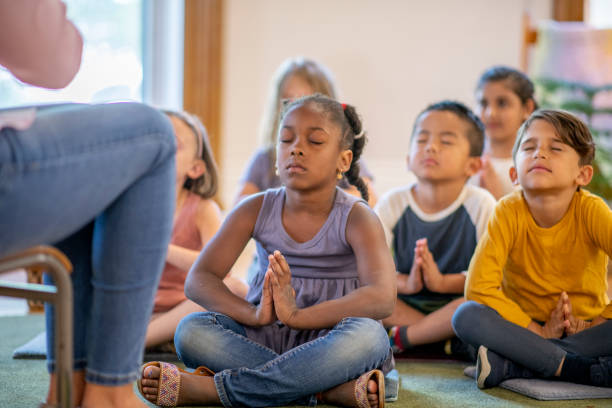 Elementary kids in the classroom Diverse group of elementary students in the classroom. mindfulness kids stock pictures, royalty-free photos & images