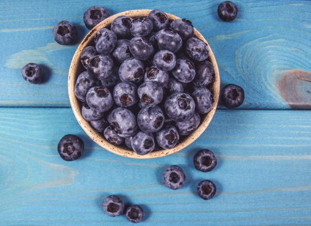 istock Raw fresh huckleberry in a bowl. Wooden background. 1167363323