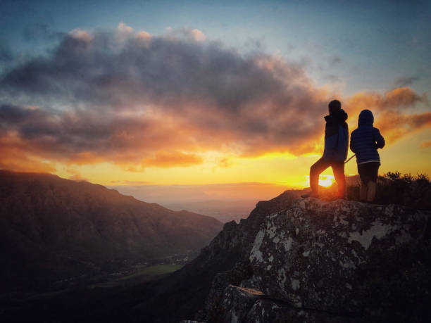istock Silhouette boys on mountain top at sunset 1167364419