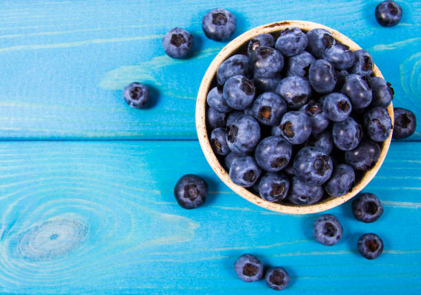 istock Raw fresh huckleberry in a bowl. Wooden background. 1167366555