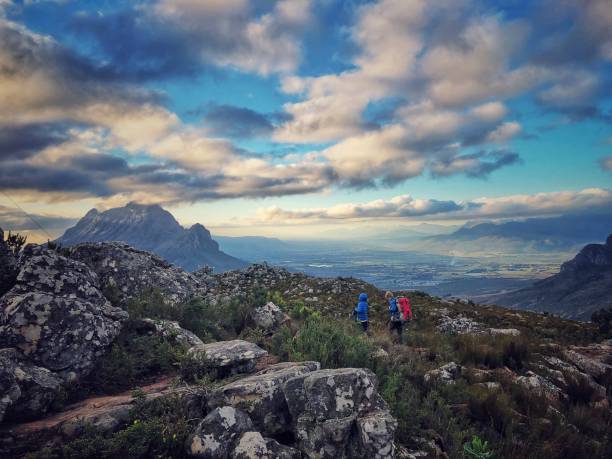 Two boys putting on backpacks on top of a mountain hike with Simonsberg and Paarl Drakenstein Valley below South Africa