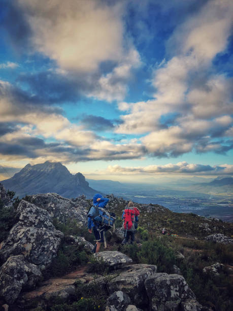 istock Boys with backpacks on top of a mountain hiking down 1167366835