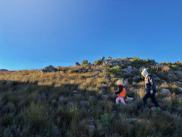 istock Young girl leading woman on a mountain path side view 1167371165