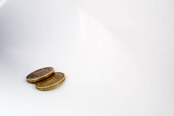 istock two copper coins lying on a sheet of white paper light shadow and light around the perimeter 1167375269