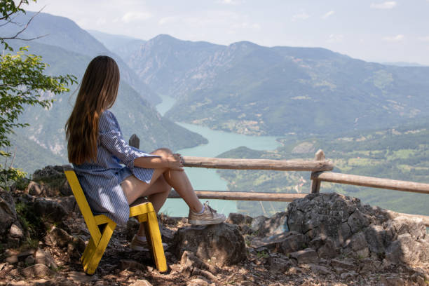 istock Young woman standing on beautiful viewpoint and looking at view 1167377201