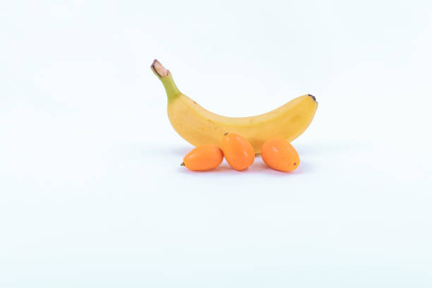 Three small sweet oranges and a ripe banana on a white background - Sweet and fresh fruits