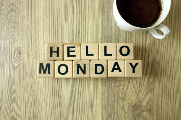 Text hello monday and cup of aromatic coffee on wooden background