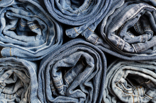 istock Denim. Lots of blue jeans rolled up. Close up 1167383378