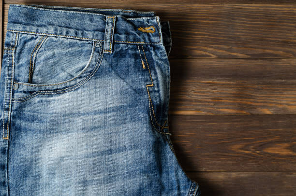 istock Denim. Blue jeans on brown wooden background. 1167383400