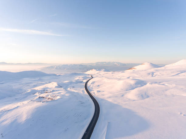 luftaufnahme einer leeren straße in der wintersaison - snow winter mountain horizon over land stock-fotos und bilder