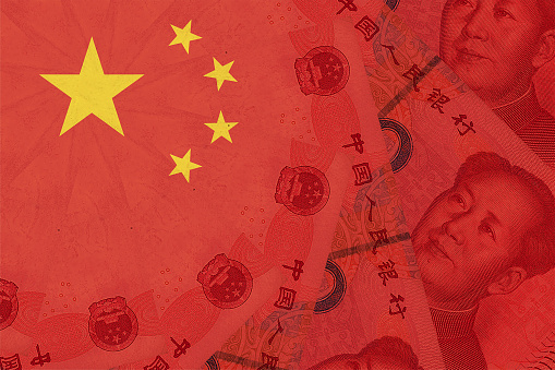 Bandera nacional de China superpuesta con billetes de renminbi Yuan. Dinero chino y situación política. Concepto de cambios en los mercados financieros y empresariales chinos photo