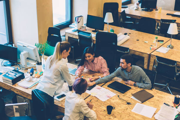 istock Top view of creative productive working process and discussion of skilled designers prepare project, male and female colleagues discussing ideas and drawing graphic together sitting a table 1167389958
