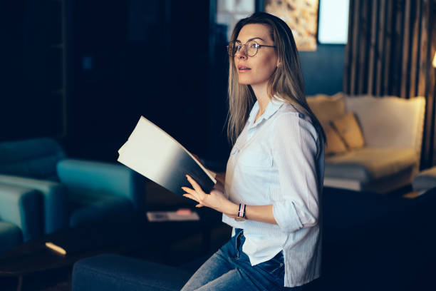 istock Young beautiful pensive smart female student in stylish shirt pondering about something while spending leisure time indoors.Cute contemplative hipster girl in eyeglasses pondering sitting on sofa 1167390049