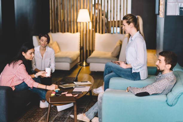 istock Crew of creative designers sitting on sofas in coworking office having brainstorming session, male and female colleagues discussing plan for startup satisfied with cooperating and communication 1167392565