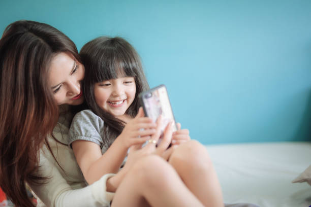 istock Portrait Happy Daughter playing smartphone with her mother 1167398366