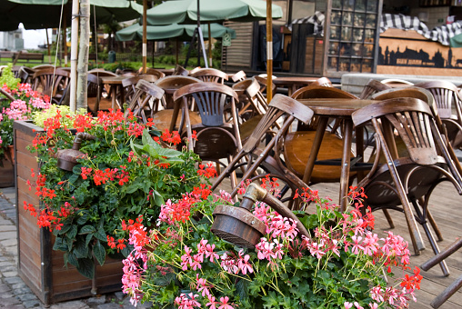 Closed cafe restaurant with wood chairs, stacked upon tables outdoor in Lviv, Ukraine