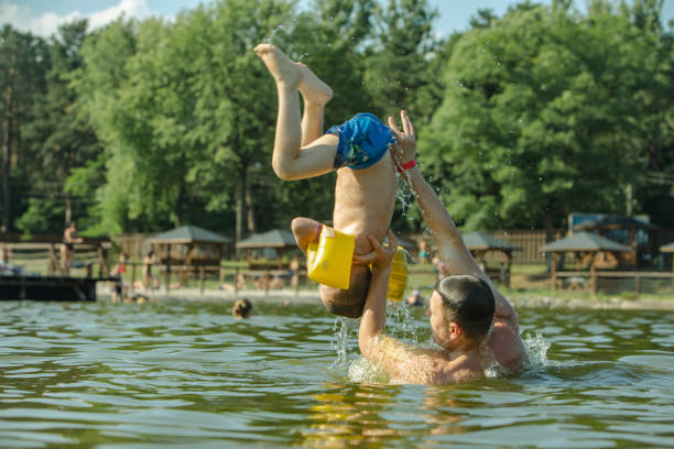 istock father throwing son in water having fun 1167406507