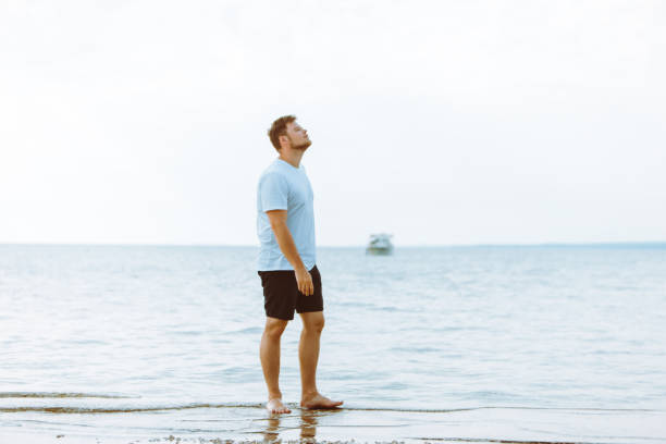 istock man walking barefoot by sea beach summer time 1167406604