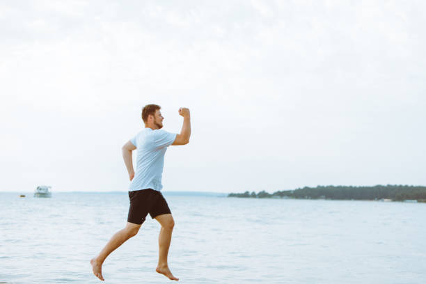 istock man running by sea beach barefoot 1167406649