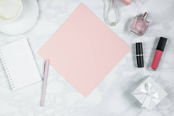 istock A pink sheet of paper, pen, notebook, perfume, gift box, pearls, of coffee. Layout for adding tags. Flat lay, copy space 1167408072