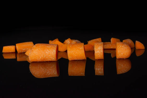 istock Orange baby carrot isolated on black glass 1167408128