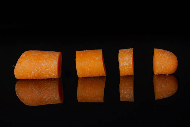 istock Orange baby carrot isolated on black glass 1167408129