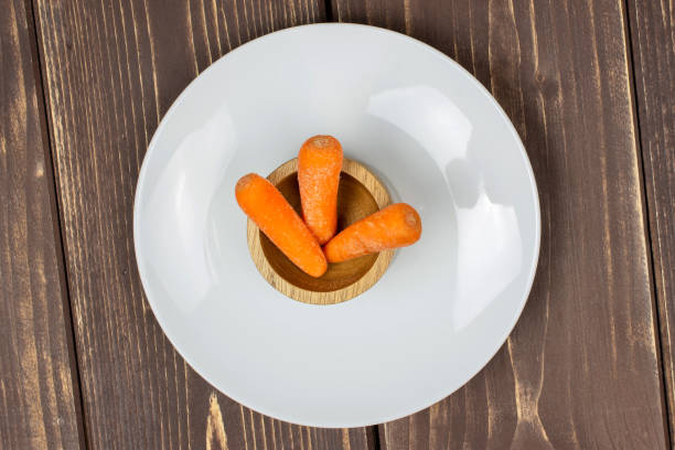 Orange baby carrot isolated on brown wood
