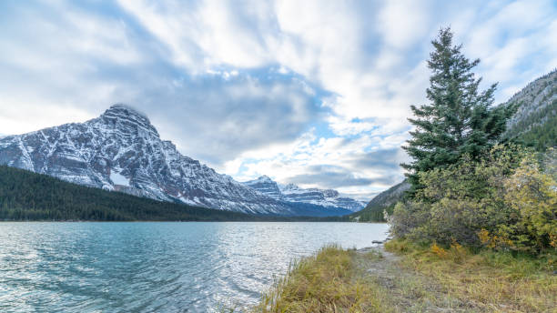 istock Bow river in Banff National park with snow cap mountains ranges under cloudyu blue sky, 1167410188