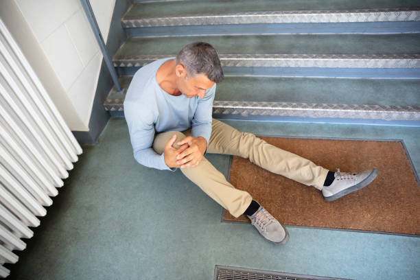 Mature Man Sitting On Staircase Mature Man Sitting On Staircase After Slip And Fall Accident slippery stock pictures, royalty-free photos & images
