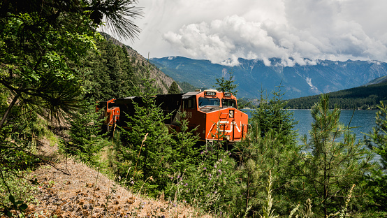 Transacanadian train crossing the country along a lake in British Columbia