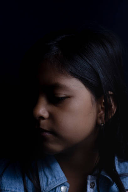 istock Cute girl illuminated between lights and shadows 1167419557