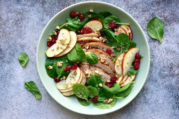 istock Spinach salad with grilled chicken breast, red apple, dried cranberry and walnuts 1167424550