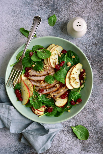 istock Spinach salad with grilled chicken breast, red apple, dried cranberry and walnuts 1167424595