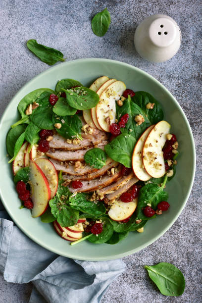 istock Spinach salad with grilled chicken breast, red apple, dried cranberry and walnuts 1167424621