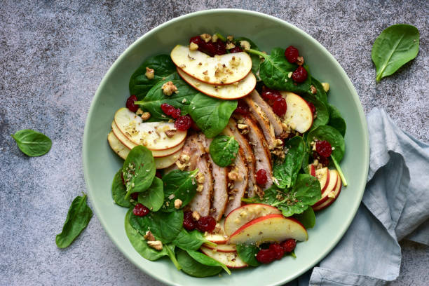 istock Spinach salad with grilled chicken breast, red apple, dried cranberry and walnuts 1167424637