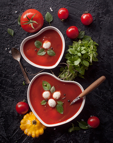 Cold tomato summer vegetable soup Gazpacho in a bowl in the shape of a heart. Vegetarian cuisine.  The view from the top.  The concept of healthy eating.