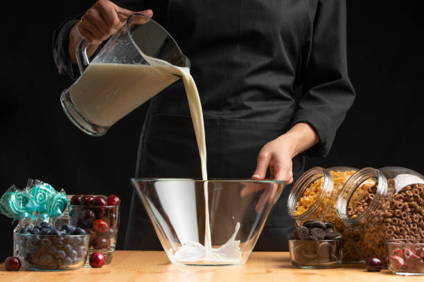 istock Pouring milk into the breakfast, freezing in motion. Cooking breakfast cereals, granules, breakfast cereals, cereals, berries of cherries, and blueberries, sweet cookies. On a black background 1167426748